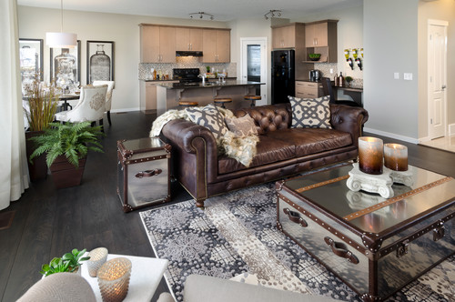 Brown leather Chesterfield sofa in a designer living room. Mirrored trunk coffee tables and side tables play nicely with the vintage theme of the room.